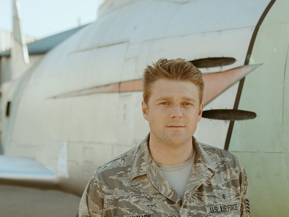 Military man standing next to plane 