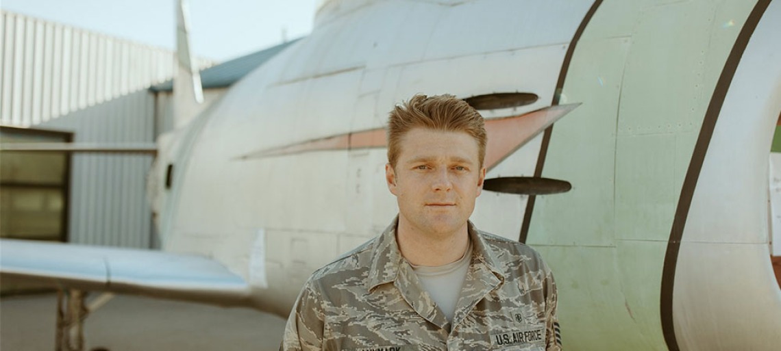 Military man standing next to plane 
