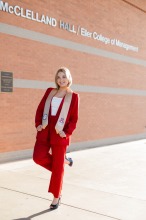 Woman in red suit standing in front of McClelland Hall.